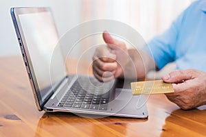 Senior hands holding credit card using laptop. Online shopping
