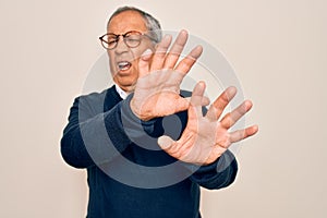 Senior handsome grey-haired man wearing sweater and glasses over isolated white background disgusted expression, displeased and
