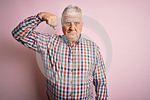 Senior handsome hoary man wearing casual colorful shirt over isolated pink background Strong person showing arm muscle, confident