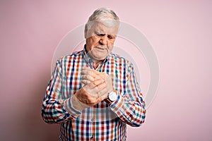 Senior handsome hoary man wearing casual colorful shirt over isolated pink background Suffering pain on hands and fingers,