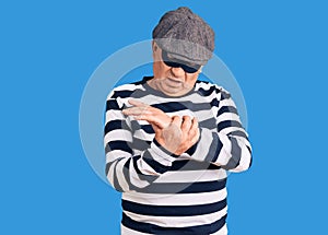 Senior handsome man wearing burglar mask and t-shirt suffering pain on hands and fingers, arthritis inflammation