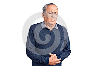 Senior handsome man wearing casual polo with hand on stomach because indigestion, painful illness feeling unwell