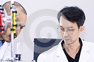 Senior handsome and smiling researcher talking with scientist