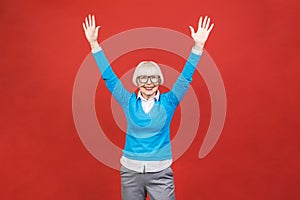 Senior happy aged businesswoman wearing glasses. Beautiful old woman looking at camera and smiling. Isolated on red background