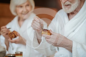 A senior happy couple enjoying breakfast while staying in bed