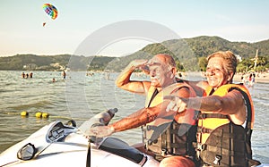 Senior happy couple having fun on jet ski at beach island hopping