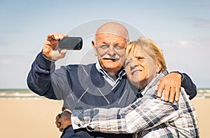 Senior happy couple taking a selfie at the beach