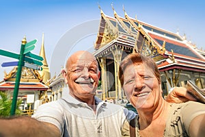 Senior happy couple taking a selfie at Grand Palace temples