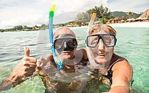 Senior happy couple taking selfie with scuba snorkeling masks