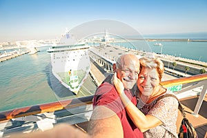 Senior happy couple taking selfie on ship at Barcelona harbour