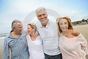 Senior happy people walking on sandy beach