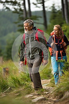 Senior hiking in high mountains with his daughter