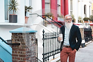 Senior hipster man going out from home while drinking coffee at morning time - Trendy lifestyle,  and joyful elderly lifestyle