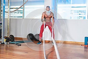 Senior hipster working out with battle ropes at the gym - Elderly fitness sport and healthy lifestyle - Mature bearded man having