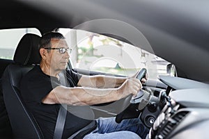 Senior in his 70s driving a car