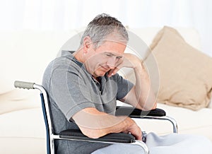 Senior in his wheelchair having a headache