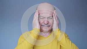 Senior hispanic adult man having terrible headache.