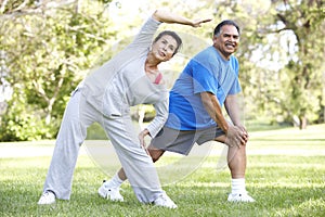 Senior Hispanic Couple Exercising In Park