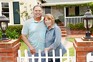 Senior Hispanic couple outside home