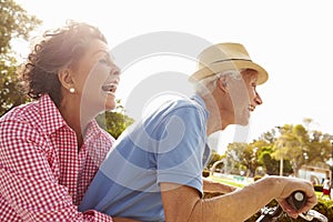 Senior Hispanic Couple Riding Bikes In Park