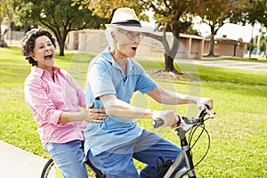 Senior Hispanic Couple Riding Bikes In Park