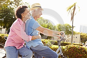 Senior Hispanic Couple Riding Bikes In Park