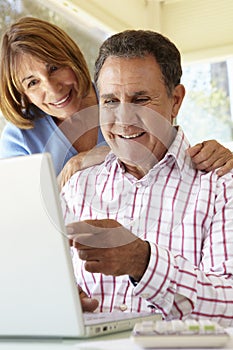 Senior Hispanic Couple Using Laptop In Home Office