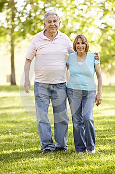 Senior Hispanic Couple Walking In Park
