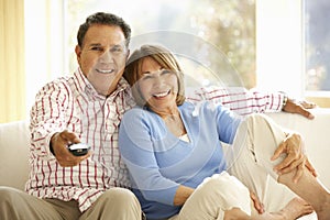 Senior Hispanic Couple Watching TV At Home