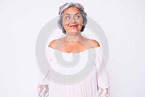 Senior hispanic grey- haired woman wearing casual clothes smiling looking to the side and staring away thinking