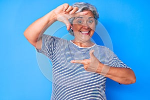 Senior hispanic grey- haired woman wearing casual clothes smiling making frame with hands and fingers with happy face