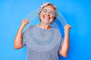 Senior hispanic grey- haired woman wearing casual clothes very happy and excited doing winner gesture with arms raised, smiling