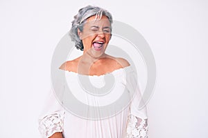 Senior hispanic grey- haired woman wearing casual clothes winking looking at the camera with sexy expression, cheerful and happy