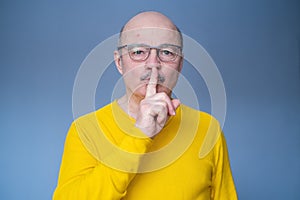 Senior hispanic man in glasses making silent
