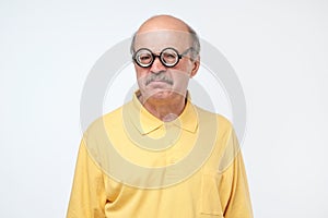 Senior hispanic man looking at camera wearing funny glasses