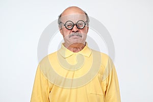 Senior hispanic man looking at camera wearing funny glasses