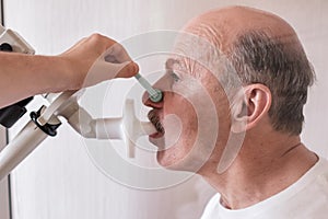 Senior hispanic man man testing breathing function by spirometry