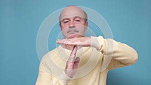 Senior hispanic man showing time out, refusing and doing time out gesture