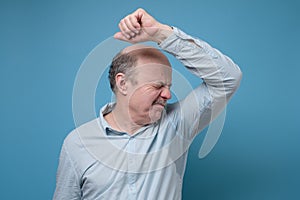 Senior hispanic man with sweaty shirt because of hyperhidrosis or hot weather