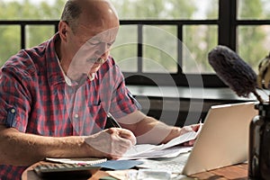 Senior hispanic man using calculator and calculate bills