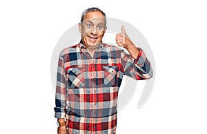 Senior hispanic man wearing casual clothes smiling happy and positive, thumb up doing excellent and approval sign