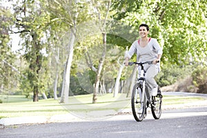 Senior Hispanic Woman Cycling In Park photo