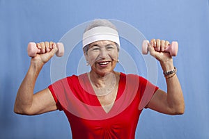 Senior hispanic woman in a sweatband lifting weights photo