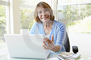 Senior Hispanic Woman Using Laptop In Home Office