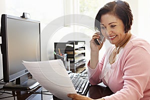 Senior Hispanic woman working on computer at home