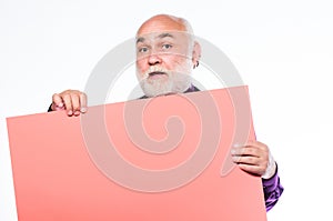 Senior holding blank sign board and looking at camera. Elderly people. Man bold head and gray beard hold poster for