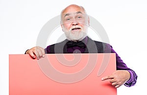 Senior holding blank sign board and looking at camera. Man bold head and gray beard hold poster for advertisement copy