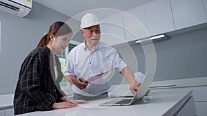 Senior home inspector checking home defects and teaching young engineers, before handing it over to client. Young engineers learn