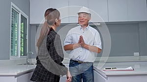 Senior home inspector checking home defects and teaching young engineers, before handing it over to client. Young engineers learn