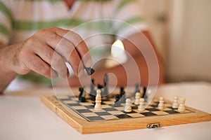 Senior human hand holding chess figure.